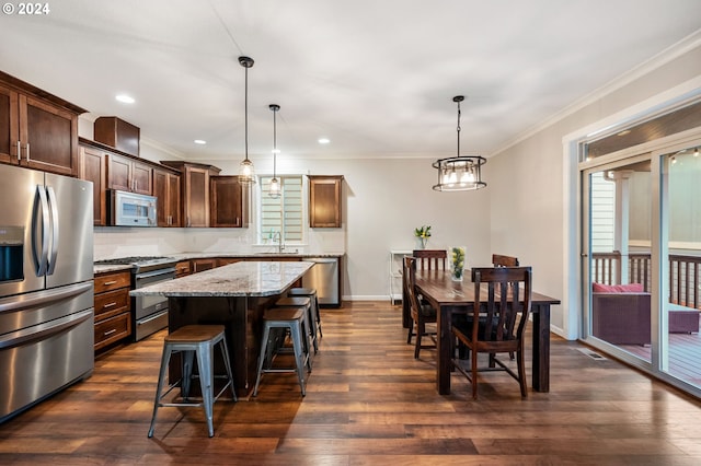 kitchen featuring a kitchen island, hanging light fixtures, dark hardwood / wood-style floors, and appliances with stainless steel finishes