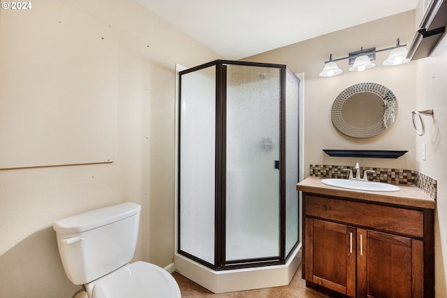 bathroom featuring tile patterned floors, toilet, vanity, and walk in shower