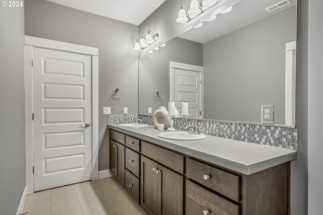 bathroom with vanity, tile patterned flooring, and tasteful backsplash