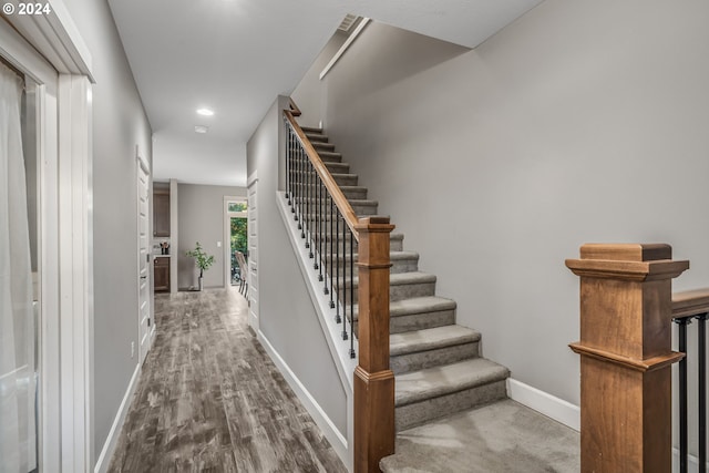 staircase with hardwood / wood-style floors