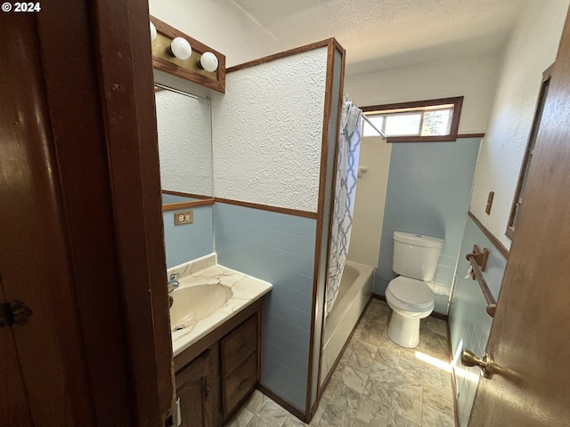 full bathroom featuring shower / bath combination with curtain, a textured ceiling, toilet, vanity, and tile patterned floors