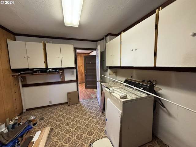 kitchen with washer / clothes dryer, a textured ceiling, white cabinets, and dark tile patterned flooring