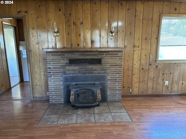 interior details with a wood stove, washer / dryer, hardwood / wood-style flooring, and wooden walls