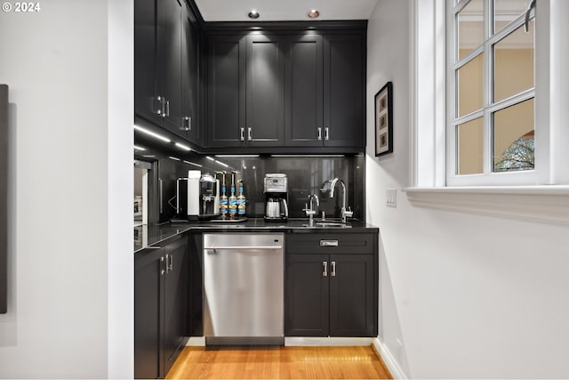 bar featuring dishwasher, sink, light hardwood / wood-style flooring, and tasteful backsplash