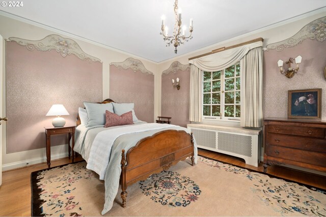 bedroom featuring crown molding, light hardwood / wood-style floors, a notable chandelier, and radiator heating unit