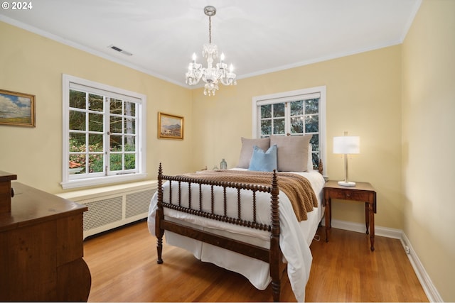 bedroom with crown molding, radiator, hardwood / wood-style floors, and a chandelier