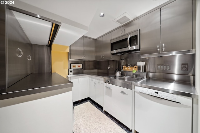 kitchen with backsplash, stainless steel appliances, and stainless steel counters