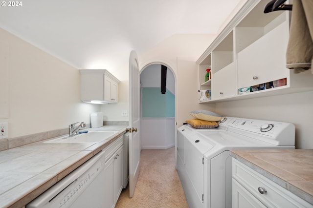 laundry room with light colored carpet, washer and clothes dryer, sink, and cabinets