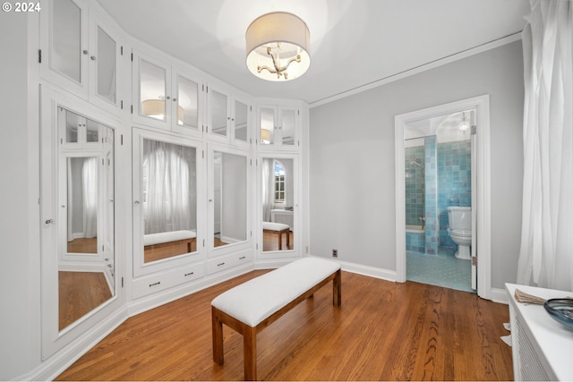 interior space featuring a notable chandelier, wood-type flooring, and crown molding