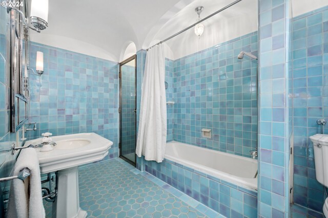 bathroom featuring tile walls, toilet, shower / tub combo with curtain, and tile patterned floors