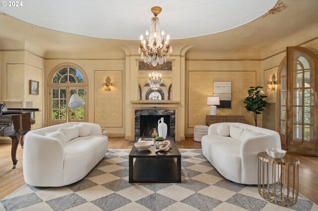 living room featuring a high end fireplace, hardwood / wood-style floors, and a notable chandelier