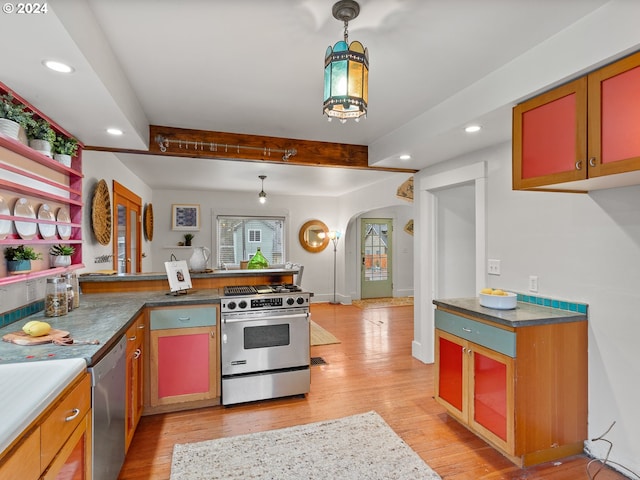 kitchen with kitchen peninsula, pendant lighting, light wood-type flooring, appliances with stainless steel finishes, and beamed ceiling