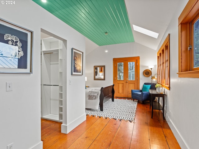 interior space featuring wood ceiling, lofted ceiling with skylight, french doors, and light wood-type flooring