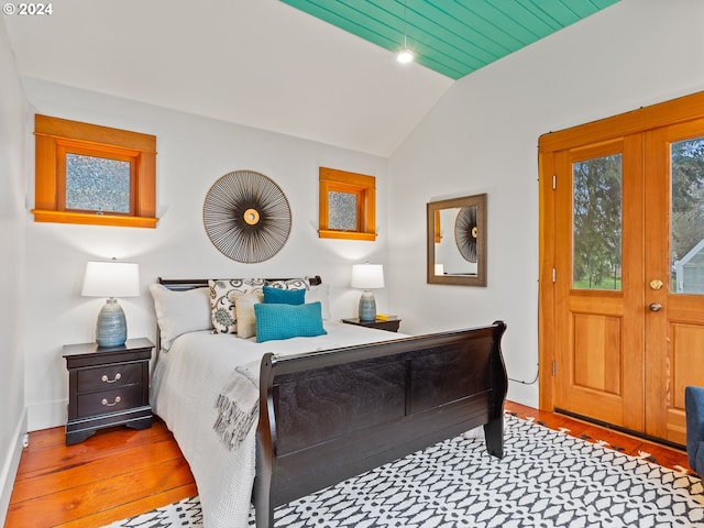 bedroom featuring lofted ceiling, french doors, and hardwood / wood-style floors