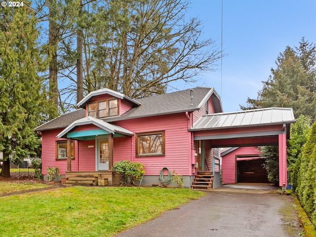 view of front facade featuring a carport, a front yard, a garage, and an outdoor structure