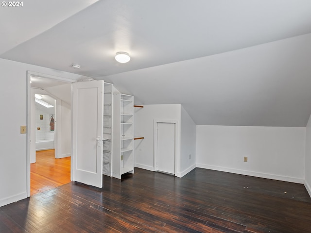 additional living space with lofted ceiling and dark hardwood / wood-style flooring