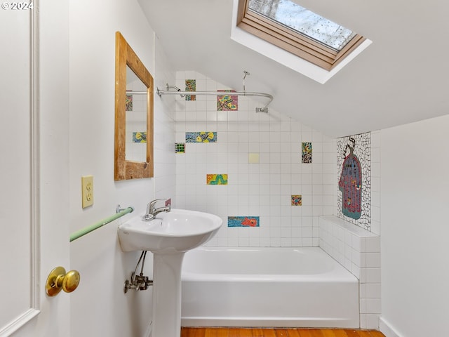 bathroom featuring lofted ceiling with skylight and hardwood / wood-style flooring