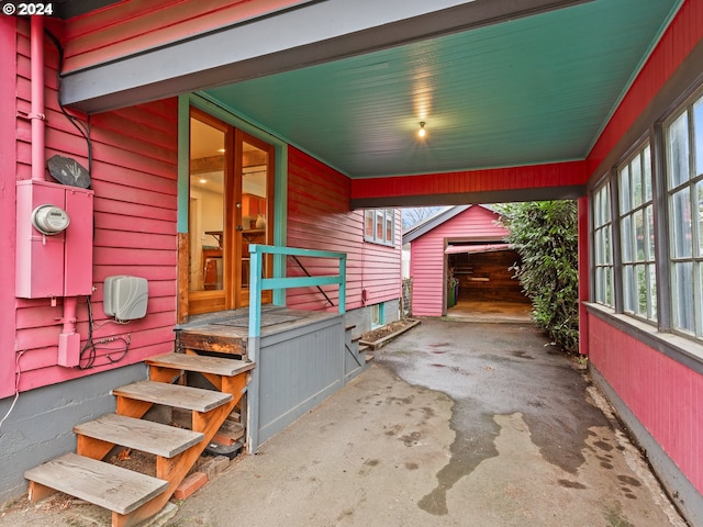 view of patio featuring a garage and an outbuilding