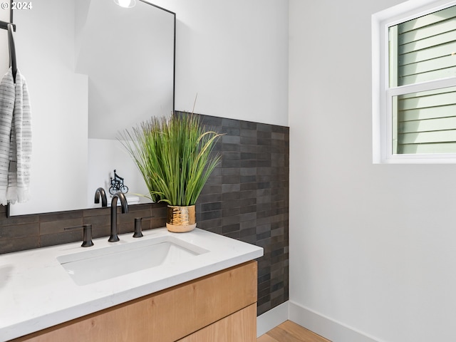 bathroom with hardwood / wood-style floors, vanity, and tile walls