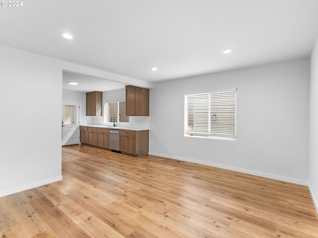 kitchen featuring dishwasher, sink, and light hardwood / wood-style floors