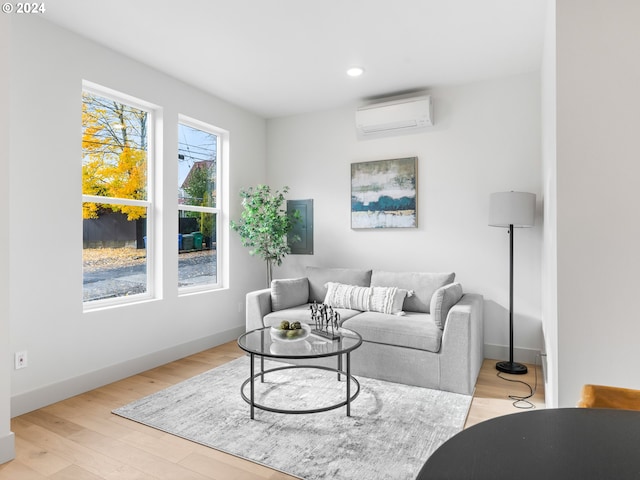 living room featuring a wall unit AC and light hardwood / wood-style floors