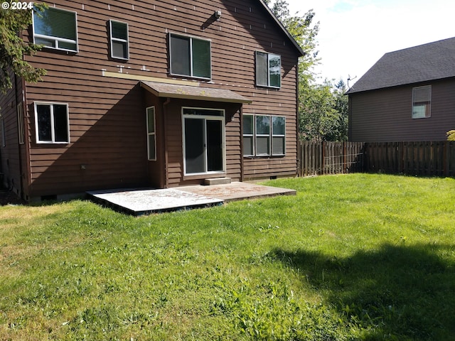 rear view of house featuring a lawn and a patio area