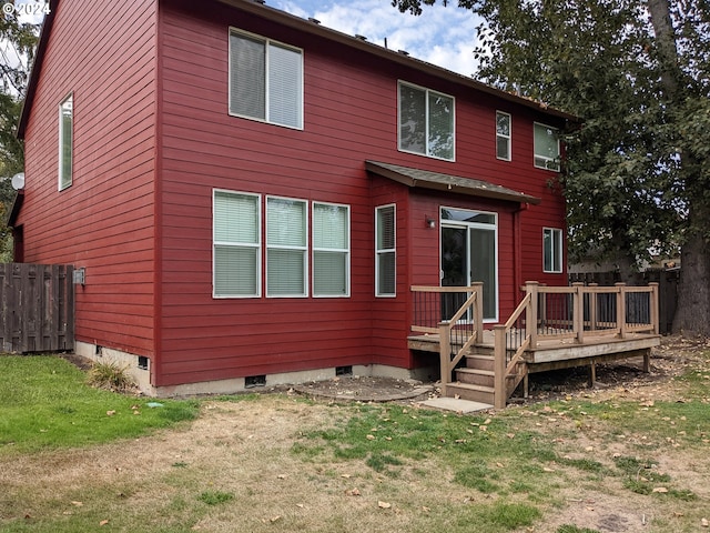 rear view of property with a lawn and a deck