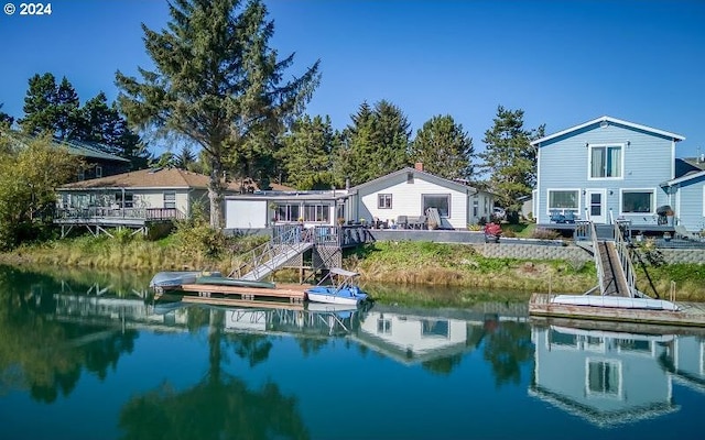 rear view of house featuring stairway and a water view