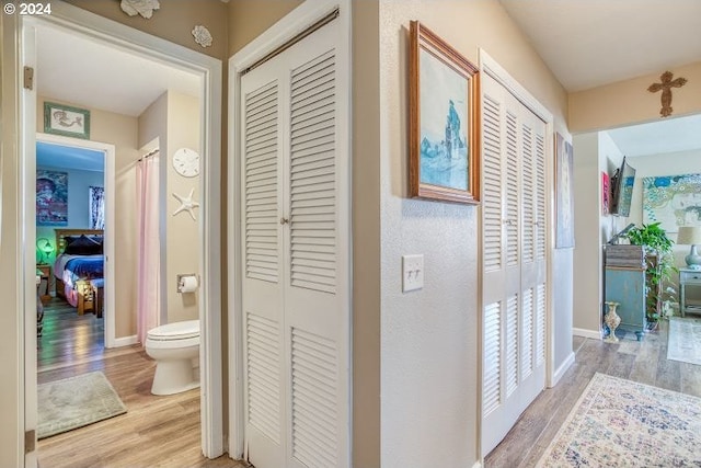 corridor with light wood-style flooring and baseboards