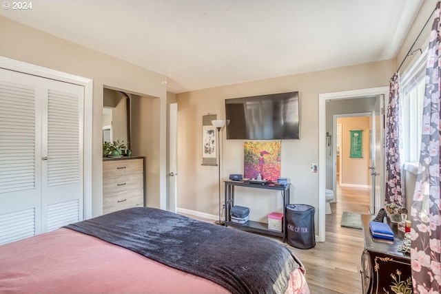 bedroom featuring light wood finished floors, a closet, and baseboards