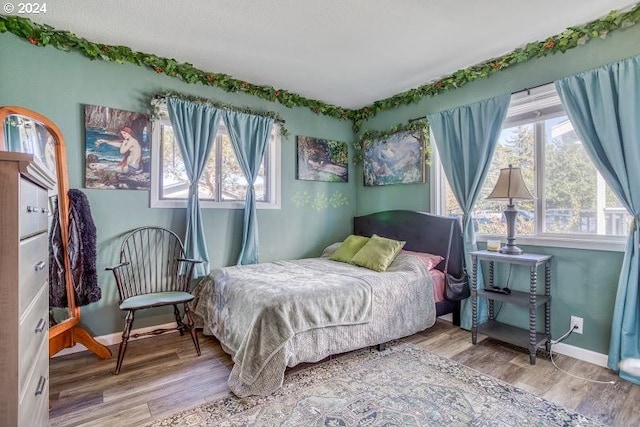 bedroom featuring wood finished floors and baseboards