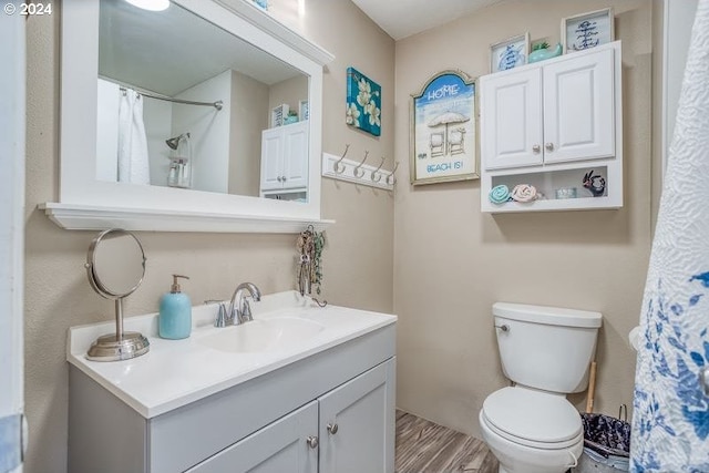 bathroom featuring a shower with curtain, vanity, toilet, and wood finished floors