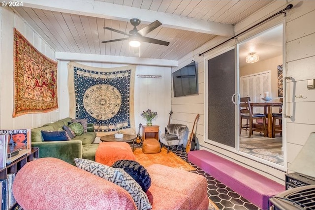 interior space with ceiling fan, wooden ceiling, beam ceiling, and wooden walls