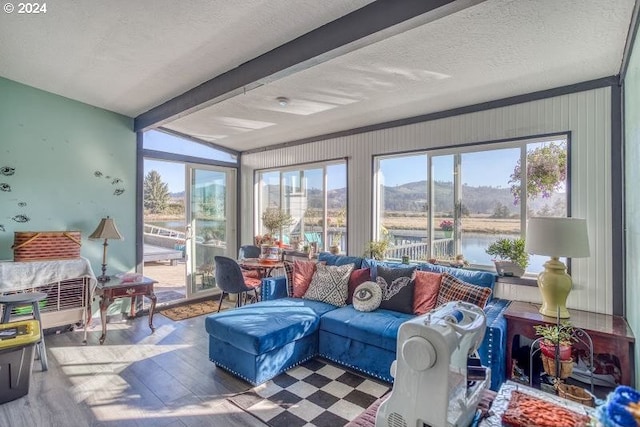 sunroom featuring beam ceiling and a water view