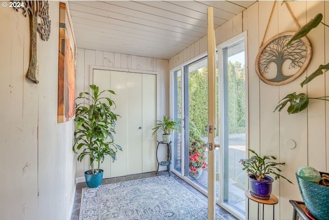 entryway featuring wood ceiling and wooden walls