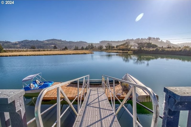 view of dock with a water and mountain view