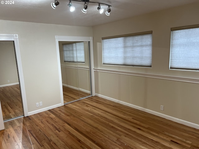 unfurnished bedroom with a closet and hardwood / wood-style flooring