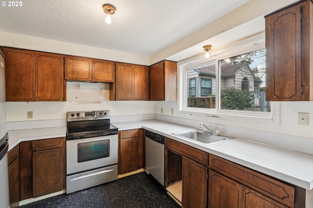 kitchen featuring stainless steel appliances, a textured ceiling, and sink