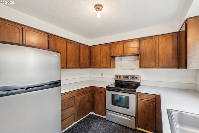 kitchen featuring stainless steel appliances, a textured ceiling, and sink