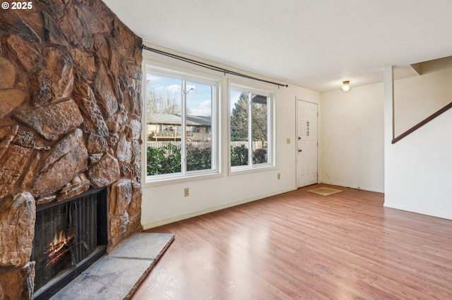 unfurnished living room featuring a fireplace and hardwood / wood-style flooring