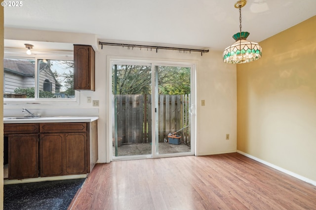 unfurnished dining area featuring sink and light wood-type flooring