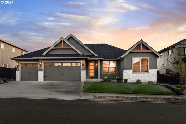 craftsman-style home featuring a yard and a garage