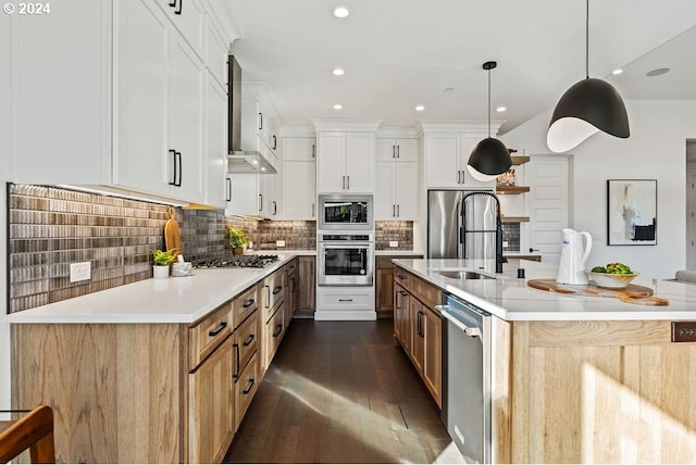 kitchen featuring white cabinets, decorative light fixtures, a large island with sink, and appliances with stainless steel finishes