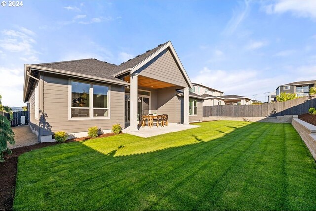 back of house with a lawn and a patio area