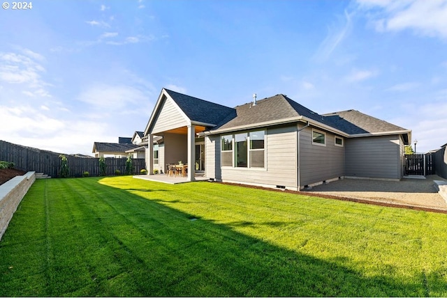 rear view of property with a yard and a patio