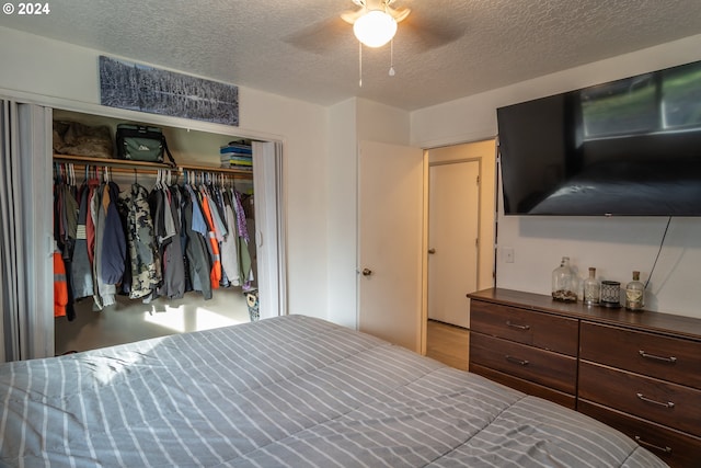 bedroom featuring ceiling fan, a closet, and a textured ceiling