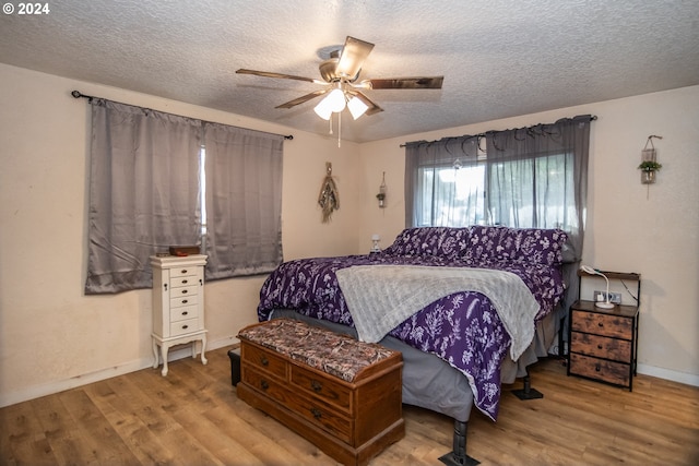 bedroom featuring ceiling fan, a textured ceiling, and hardwood / wood-style flooring