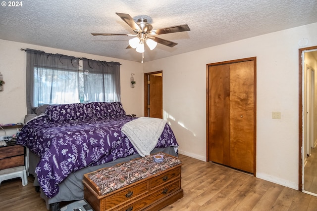 bedroom featuring ceiling fan, light hardwood / wood-style floors, and a textured ceiling