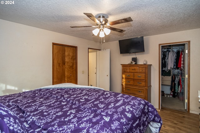 bedroom featuring ceiling fan, wood-type flooring, and a textured ceiling