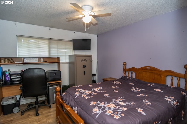 bedroom featuring ceiling fan, light hardwood / wood-style flooring, and a textured ceiling